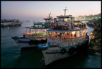 Lighted tour boat at quay,  sunset. Mumbai, Maharashtra, India