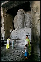 Woman and children standing in front of Mahesh Murti, main  Elephanta cave. Mumbai, Maharashtra, India (color)