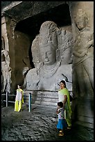 Woman and children standing in front of Mahesh Murti, main  Elephanta cave. Mumbai, Maharashtra, India