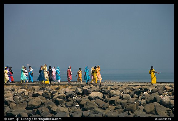 Women walking on  jetty in the distance, Elephanta Island. Mumbai, Maharashtra, India (color)