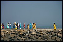 Women walking on  jetty in the distance, Elephanta Island. Mumbai, Maharashtra, India