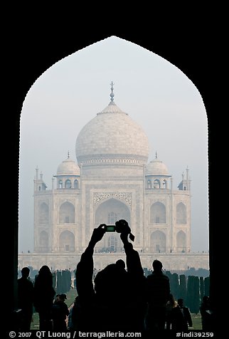 Tourist pointing  digital camera to Maj Mahal, framed by arch of gateway. Agra, Uttar Pradesh, India (color)