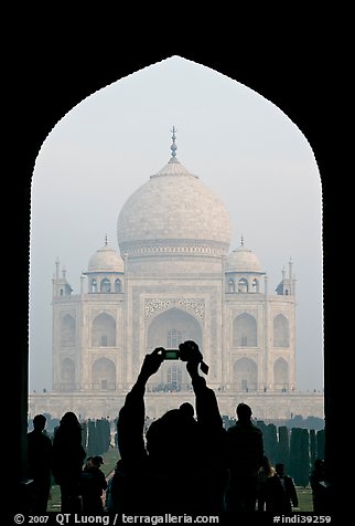 Tourist pointing  digital camera to Maj Mahal, framed by arch of gateway. Agra, Uttar Pradesh, India