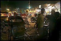 Cycle-rickshaws and vending booths at night, Agra cantonment. Agra, Uttar Pradesh, India (color)