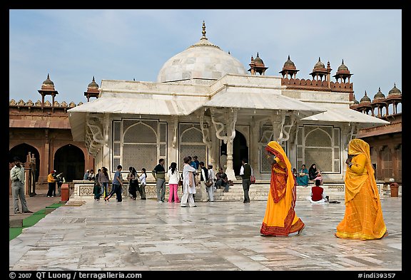 Two women walking outside the white marble  Shaikh Salim Chishti tomb. Fatehpur Sikri, Uttar Pradesh, India