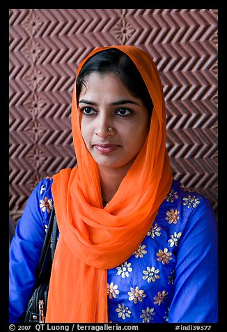 Young woman with bright scarf, in front of Rumi Sultana motifs. Fatehpur Sikri, Uttar Pradesh, India (color)