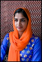 Young woman with bright scarf, in front of Rumi Sultana motifs. Fatehpur Sikri, Uttar Pradesh, India ( color)