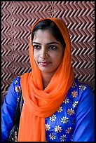 Young woman with bright scarf, in front of Rumi Sultana motifs. Fatehpur Sikri, Uttar Pradesh, India