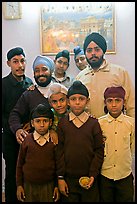 Sikh men and boys in front of picture of the Golden Temple. Bharatpur, Rajasthan, India