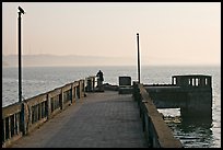 Pier with man fishing, early morning, Dona Paula. Goa, India (color)