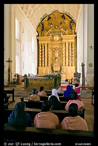 Indian women sitting in front of the altar, Basilica of Bom Jesus, Old Goa. Goa, India