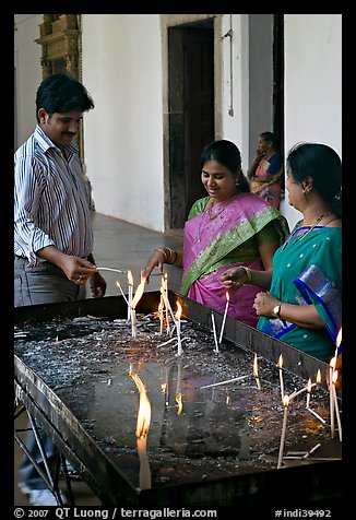 Man and two women burning candles, Basilica of Bom Jesus, Old Goa. Goa, India (color)