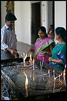Man and two women burning candles, Basilica of Bom Jesus, Old Goa. Goa, India (color)