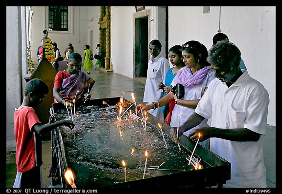Indian people burning candles, Basilica of Bom Jesus, Old Goa. Goa, India (color)