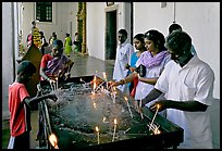 Indian people burning candles, Basilica of Bom Jesus, Old Goa. Goa, India