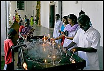 Indian people burning candles, Basilica of Bom Jesus, Old Goa. Goa, India (color)