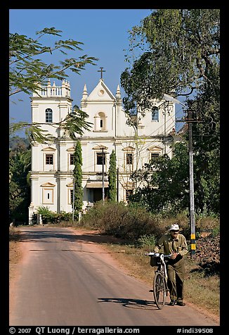 Man walking a bicycle in front of church of St John, Old Goa. Goa, India (color)