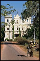 Man walking a bicycle in front of church of St John, Old Goa. Goa, India