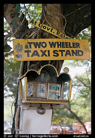 Two wheeler taxi stand and altar on tree. Goa, India (color)