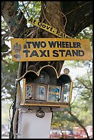 Two wheeler taxi stand and altar on tree. Goa, India