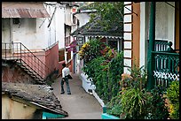 Man in alley with gardens, Panjim. Goa, India