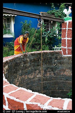 Woman retrieving water from well, Panaji. Goa, India (color)