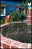 Woman retrieving water from well, Panaji. Goa, India