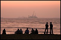 People and  off-shore platforms, Miramar Beach, sunset. Goa, India (color)