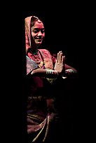 Woman joining hands in prayer gesture with dramatic lighting, Kandariya show. Khajuraho, Madhya Pradesh, India