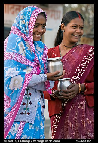 Women with pots used for religious offerings. Khajuraho, Madhya Pradesh, India (color)