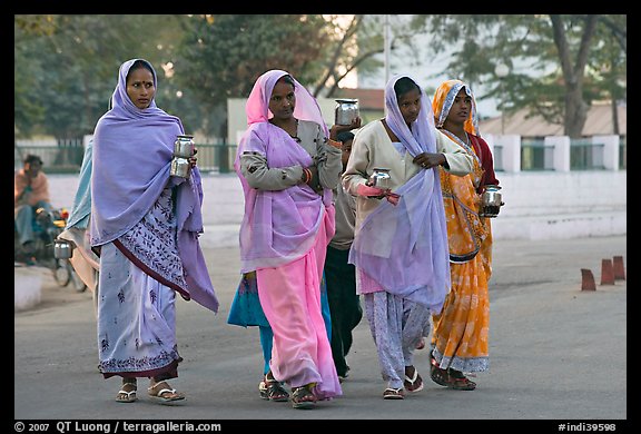 Hindu women walking in street with pots. Khajuraho, Madhya Pradesh, India