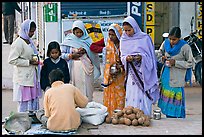 Hindu women purchasing offerings before going to temple. Khajuraho, Madhya Pradesh, India ( color)