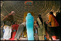 Worshipers and polished lingam inside Matangesvara temple. Khajuraho, Madhya Pradesh, India ( color)