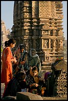 Women offering morning puja  in front temple spire. Khajuraho, Madhya Pradesh, India