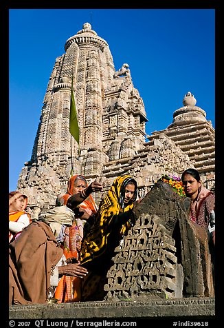 Hindu worshippers making offerings with Lakshmana temple behind. Khajuraho, Madhya Pradesh, India (color)