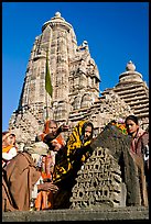 Hindu worshippers making offerings with Lakshmana temple behind. Khajuraho, Madhya Pradesh, India (color)