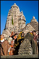 Hindu worshippers making offerings with Lakshmana temple behind. Khajuraho, Madhya Pradesh, India