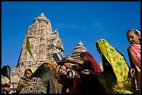 Hindu women making offerings to image with Lakshmana temple behind. Khajuraho, Madhya Pradesh, India ( color)