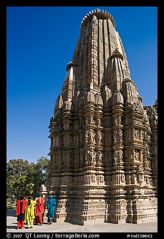 Women walking at the base of the sikhara of Devi Jagadamba temple. Khajuraho, Madhya Pradesh, India (color)