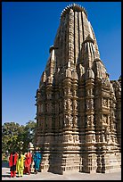 Women walking at the base of the sikhara of Devi Jagadamba temple. Khajuraho, Madhya Pradesh, India (color)