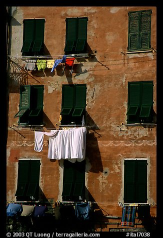 Typical terra cotta facade with hanging laundry and green shutters, Vernazza. Cinque Terre, Liguria, Italy