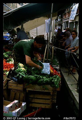 Selling fruit and vegetable from a boat on a small  canal, Castello. Venice, Veneto, Italy