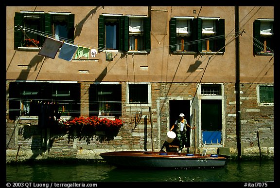 Resident stepping from his boat to his house,  Castello. Venice, Veneto, Italy (color)