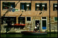 Resident stepping from his boat to his house,  Castello. Venice, Veneto, Italy (color)