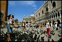 Tourists feeding  pigeons, Piazzetta San Marco (Square Saint Mark), mid-day. Venice, Veneto, Italy ( color)