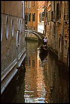 Gondola and reflections in a narrow canal. Venice, Veneto, Italy