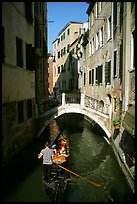 Gondola tour in a picturesque canal with bridge. Venice, Veneto, Italy