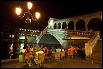 Outdoor cafe terrace,  Rialto Bridge at night. Venice, Veneto, Italy