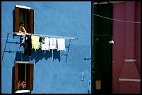 Woman hangs laundry to dry, Burano. Venice, Veneto, Italy (color)