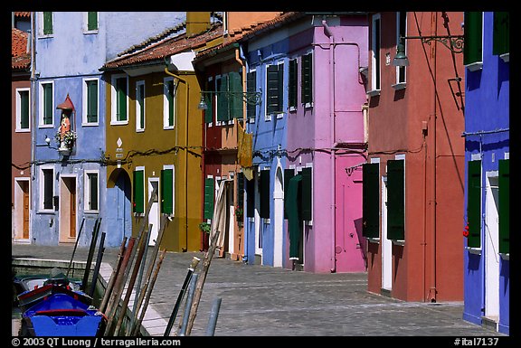 Sidewalk and row of brightly painted houses, Burano. Venice, Veneto, Italy